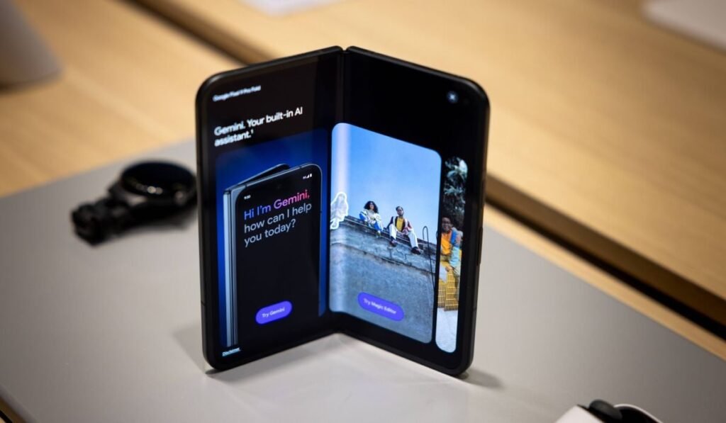 Un telefon Google Pixel 9 Pro Fold deschis pe o masă gri de prezentare.