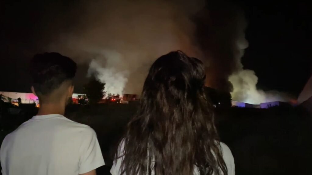 Comercianții de la Dragonul Roșu privesc flăcările care mistuie mărfurile din depozite