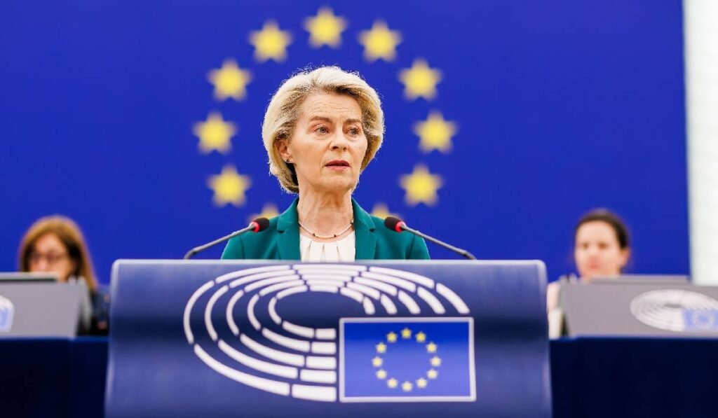 Ursula von der leyen pe fundalul unui steag al UE, vorbește de la un pupitru