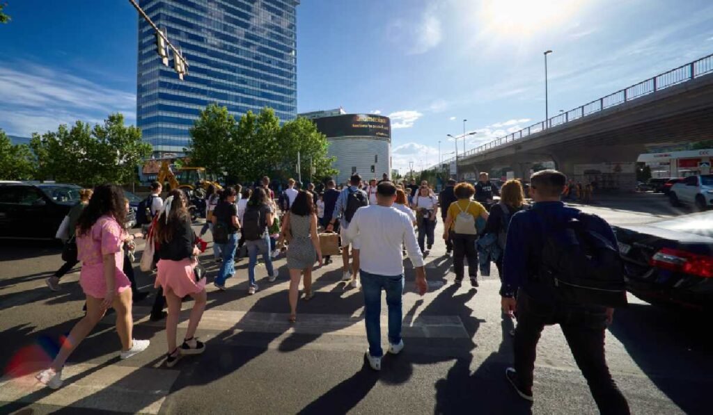 Mai multe persoane traversează strada, în București