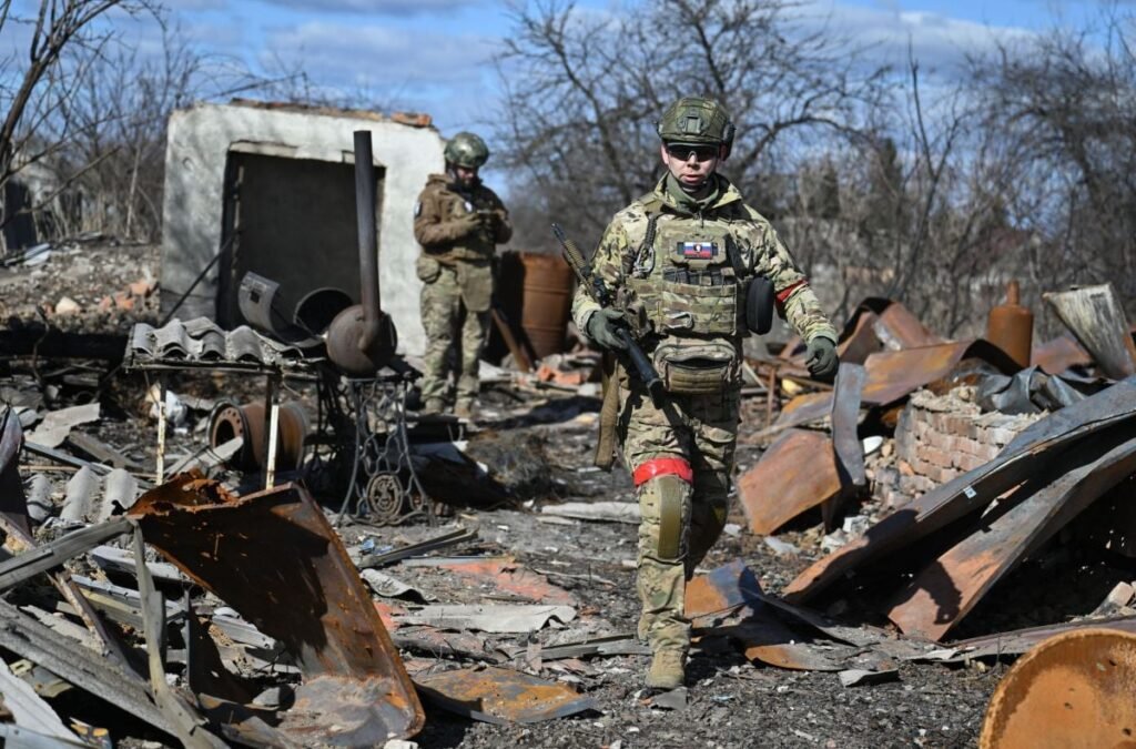 Doi militari ruși patrulează într-o zonă recent capturată de la ucraineni din orașul Sudja, regiunea Kursk, Rusia, aprilie 2025