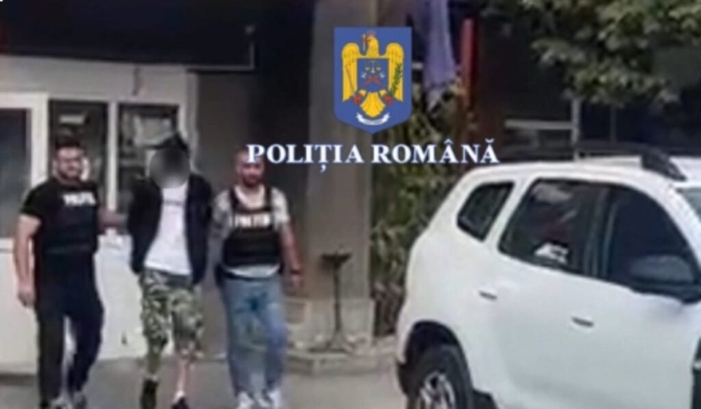 un bărbat este escortat de doi polițisti, în imagine se vede si o Dacia Duster albă