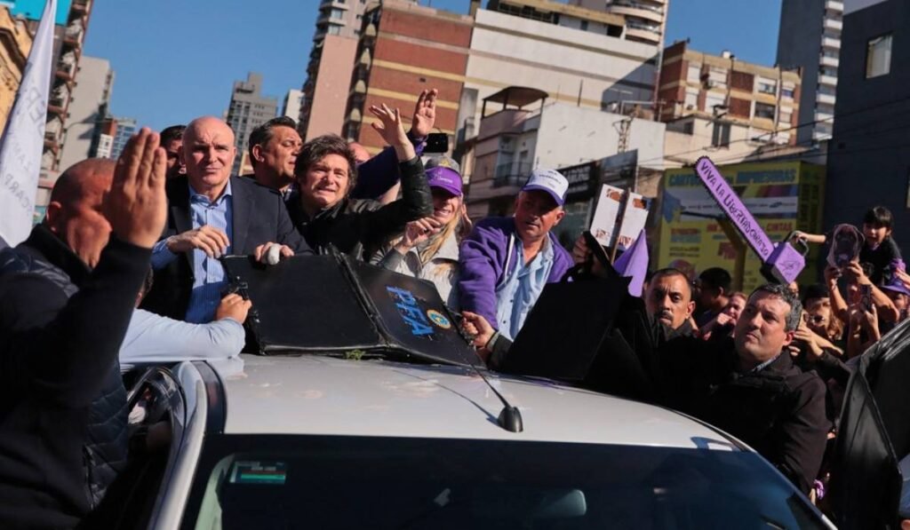 Președintele argentinian Javier Milei și echipa de campanie în mașina electorală albă, aceasta este atacată de mai mulți protestatari care încearcă să ajungă la șeful statului