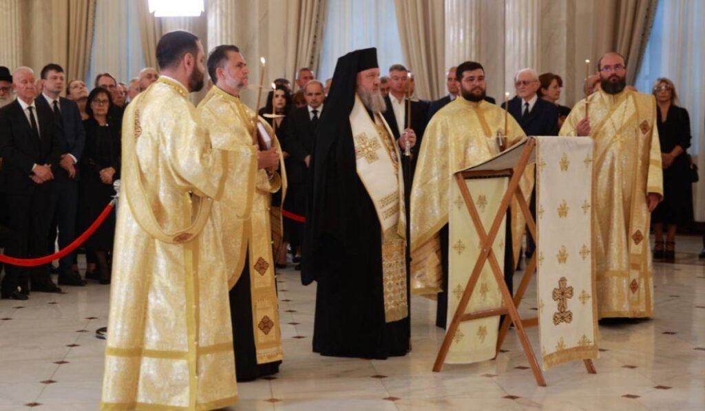 Preasfințitul Parinte Timotei Prahoveanul alături de soborul de preoți în sultane aurii care țin slujbele pentru înmormântarea lui Ion Iliescu în Sala Unirii de la Palatul Cotroceni