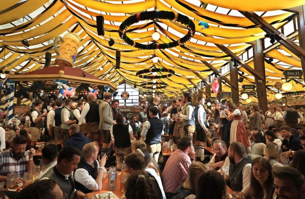 Turiștii sărbătoresc în cortul Paulaner la Oktoberfest, octombrie 2024