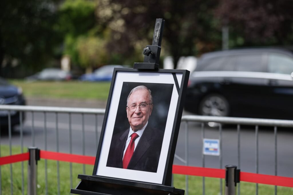 Radu Cristescu, fost deputat PSD, acuză TVR de „măcel mediatic” după moartea lui Ion Iliescu: „Cer intervenția urgentă a CNA” imaginea lui ion iliescu, într-o ramă neagră cu o banderolă neagră pe colt. rama cu imaginea este asezata într-un chenar realizat dintr-o paglică roșie, în parcarea Palatului Cotroceni, 6 august 2025