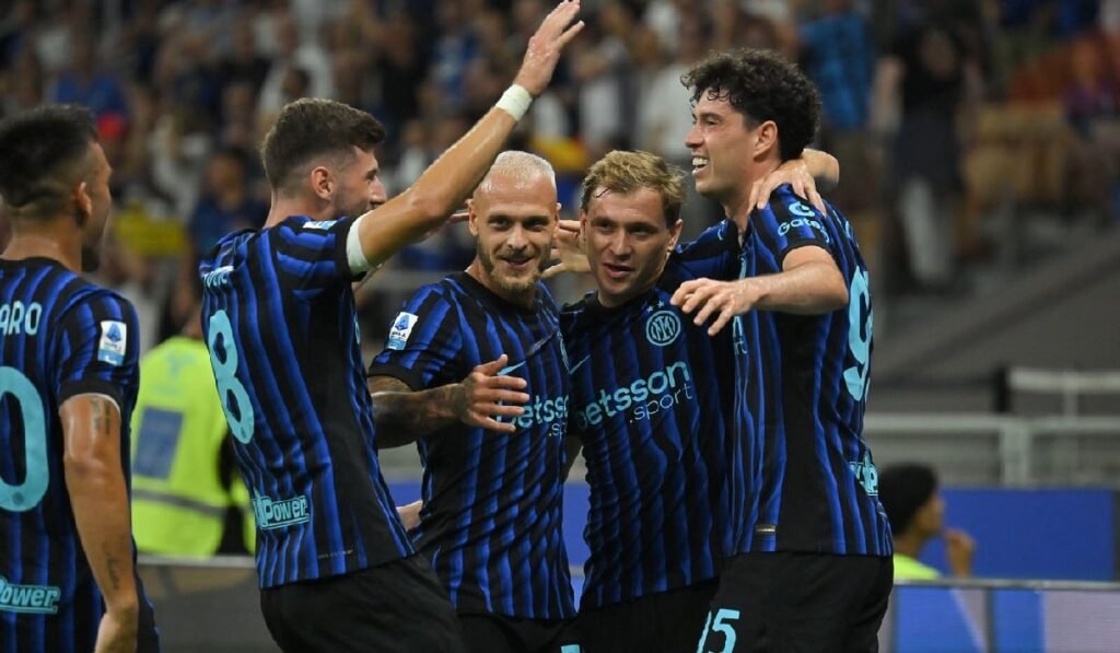 Jucătorii lui Inter Milano sărbătoresc împreună un gol pe stadion, îmbrăcați în echipamentul lor albastru-negru.