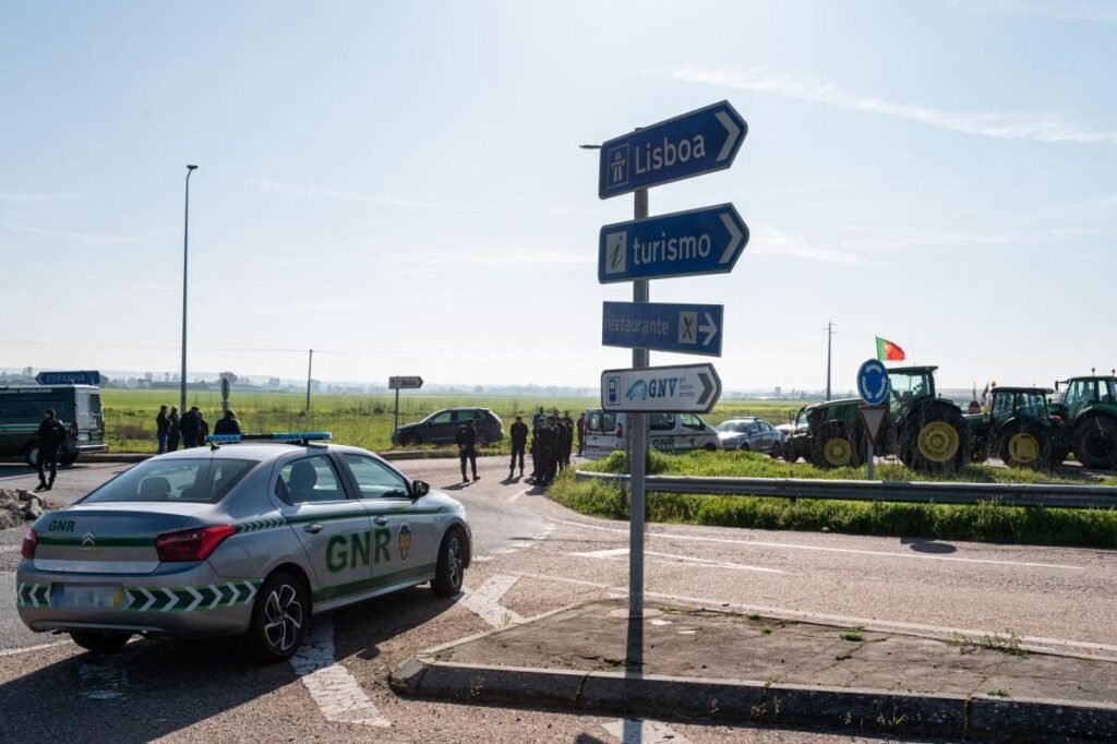 O mașină a poliției portugheze este parcată în apropierea unei autostrade blocate de fermieri, în apropierea graniței cu Spania, februarie 2024