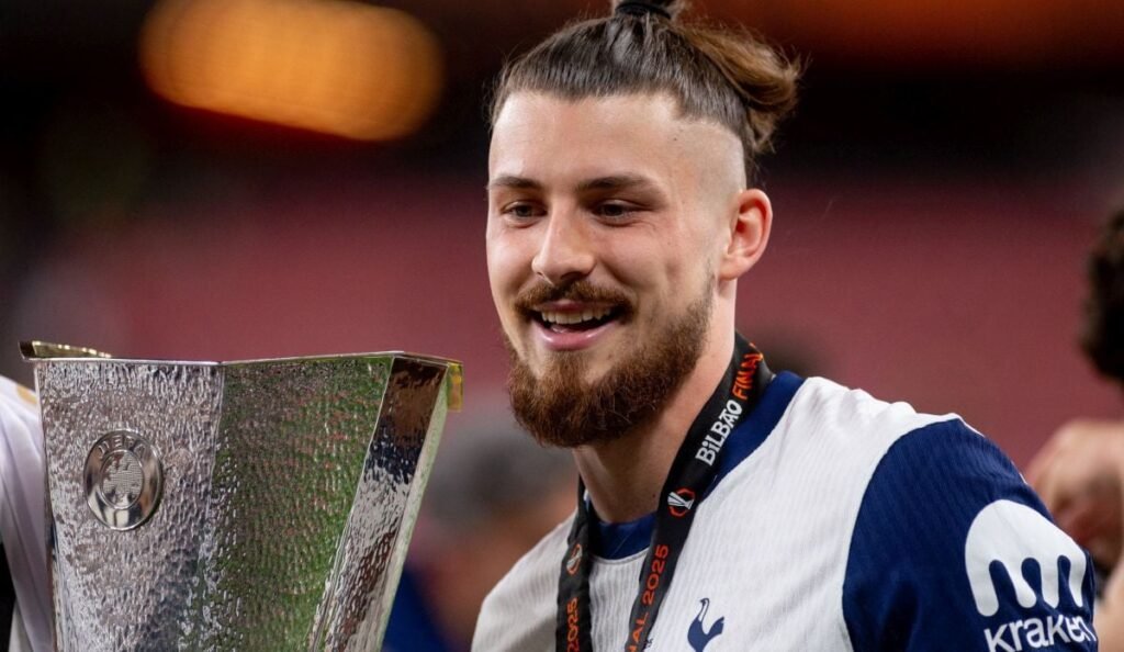 Veniturile uriașe pe care le-au obținut echipele din Premier League în anul 2024. Ce salariu are Radu Drăgușin în Anglia Radu Dragusin la o poza cu Cupa UEFA League dupa meciul de fotbal dintre Totenham Hotspur si Manchester United, contand pentru Finala UEFA League, desfasurat pe Stadionul San Mamés din Bilbao, miercuri 21 mai 2025. © FOTO: Marius Tudor/SPORT PICTURES