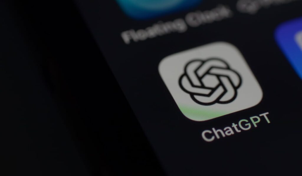 Iconița aplicației ChatGPT pe fundalul negru al ecranului unui telefon mobil.