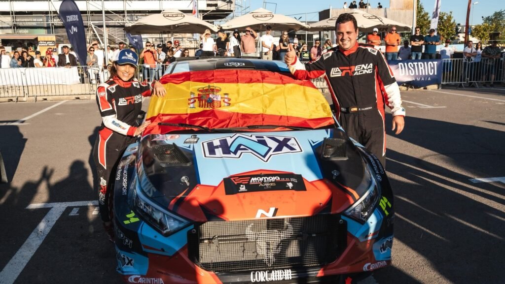 spaniolul Efren Llarena langa masina de concurs pe care este desfasurat steagul Spaniei