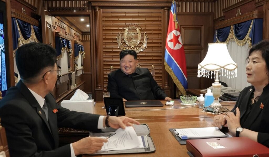 Fotografie furnizată de guvernul nord-coreean cu liderul Kim Jong Un, zambitor, asezat la birou, cu steagul pe peretele din spate, in centru, pleacă din Phenian, ,Coreea de Nord, cu trenul, luni, 1 septembrie 2025, îndreptându-se spre Beijing.