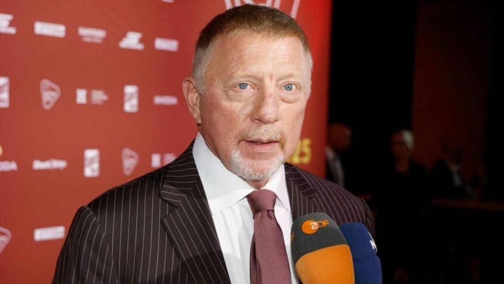 „Au venit în celulă să mă lovească” Boris Becker, 57 de ani, in costum inchis la ciloare , camasa alba si cravata maro, la decernarea premiilor Sport-Bild, Hamburg, in timpul unui interviu, cu microfonul in fata si un panou rosu cu scris alb in spate, 25 august 2025