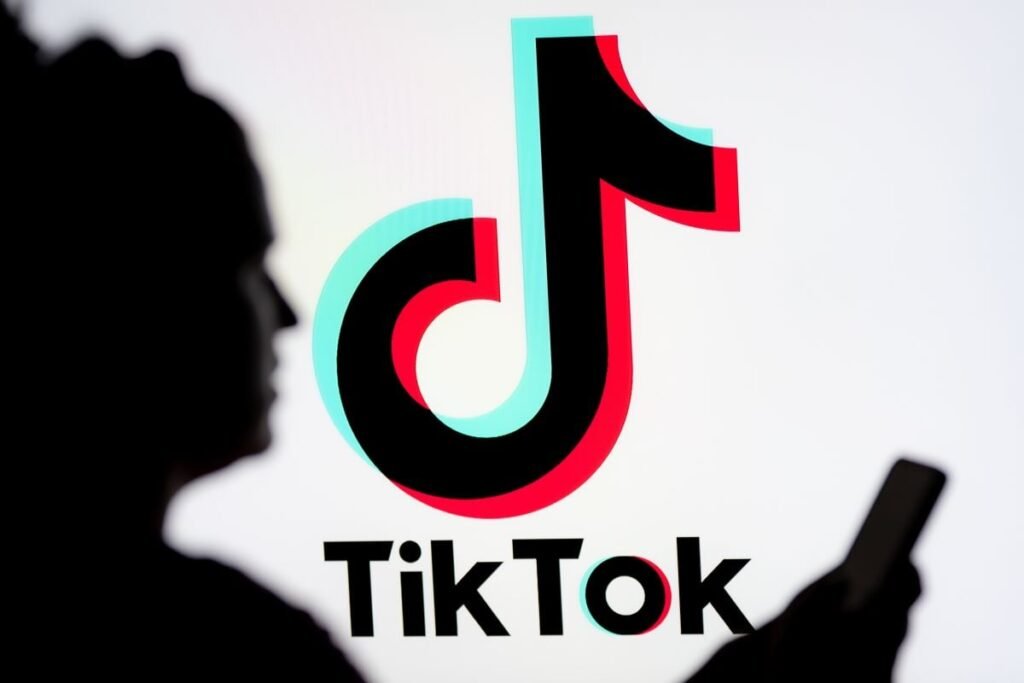 „Le consideră o formă de putere soft” O femeie se uitâ pe un smartphone cu o siglă TikTok afișată în fundal