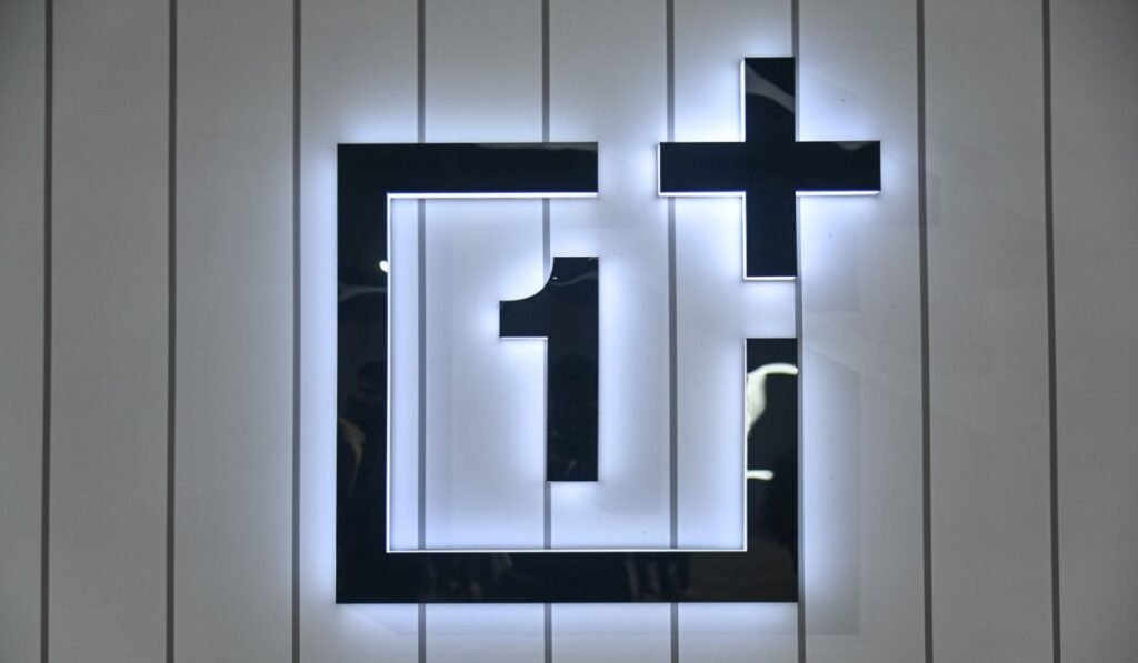 Logo-ul OnePlus, pe un fundal de panouri gri verticale.