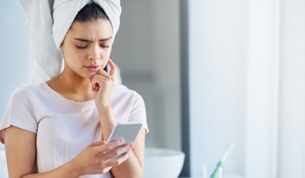 O tânără care ține un telefon în mână, în baie