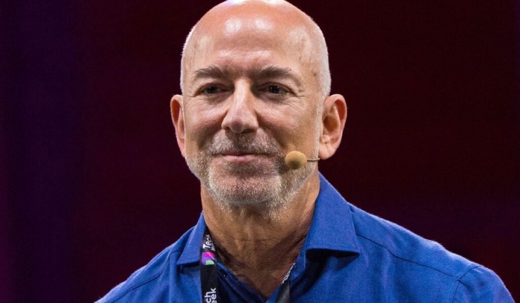Jeff Bezos, îmbrăcat într-un tricou albastru și purtând un microfon, pe scena Italian Tech Week.